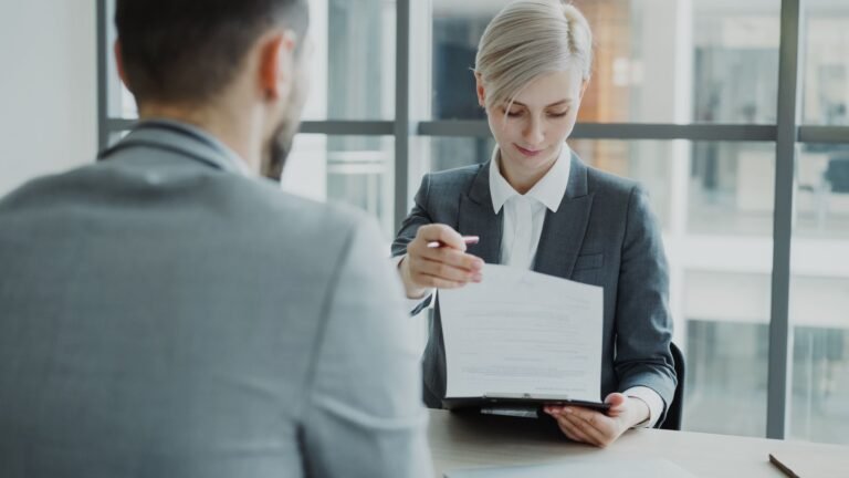 Account manager e cliente revisando o escopo de atendimento em reunião de agência